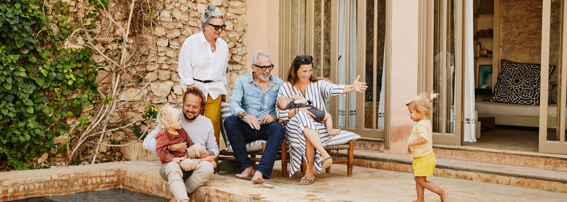 smiling multigenerational family relaxing at tropical villa